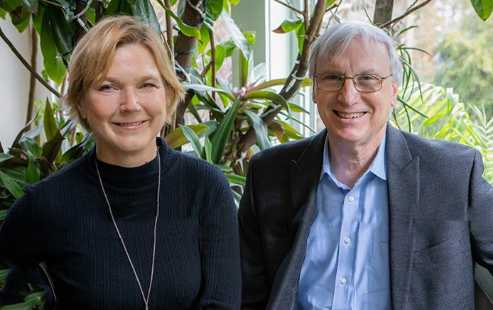 Photo of Linda Griffith and Douglas Lauffenburger side-by-side, with an indoor plant in the background