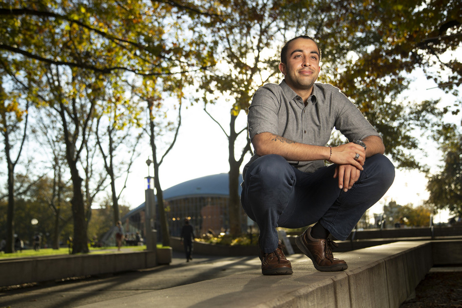Photo of Arnav Patel crouching in front of Kresge Auditorium