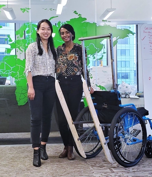 Jessica Xu and Smita Bhattacharjee standing next to their TILT wheelchair attachment