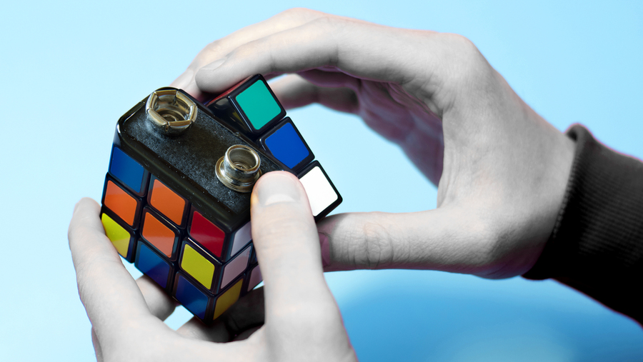 mit thesis on thermal energy storage Conceptual photo featuring two hands, each turning a section of a battery that looks like a Rubick's cube