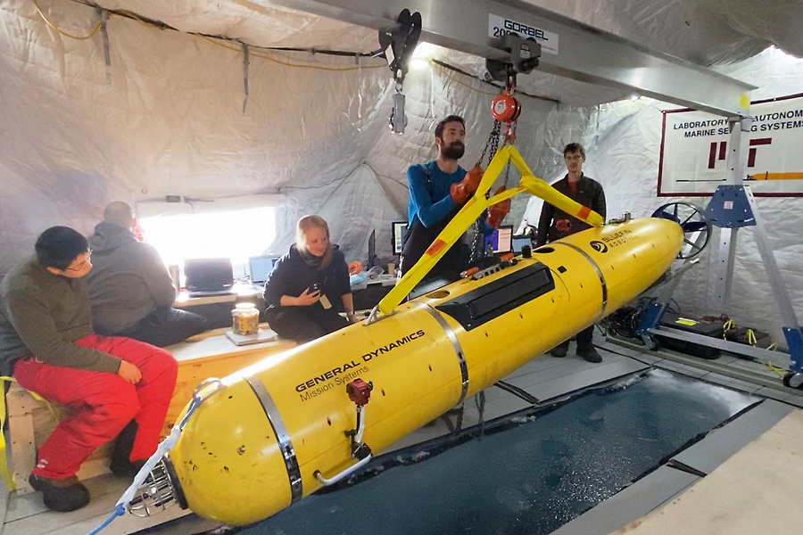 Researchers lowering underwater vehicle into the water