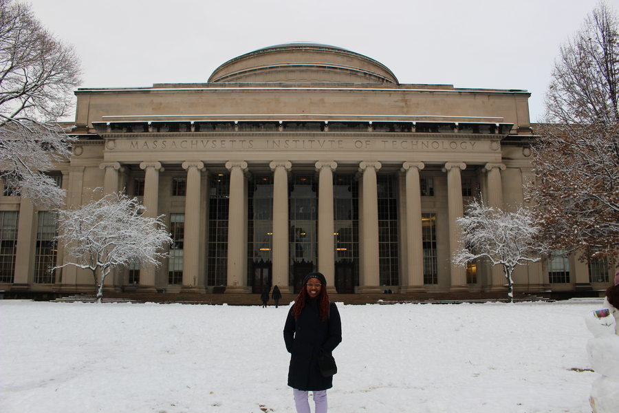 Photo of Abigael Bamgboye standing on a snow-covered Killian Court in front of the Great Dome/Building 10 on the MIT campus.