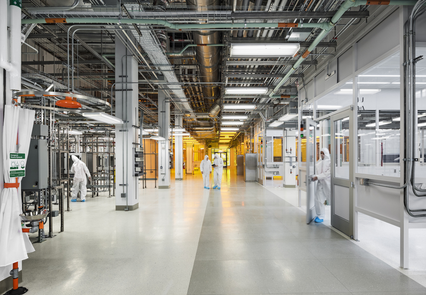 Photo of several people in cleansuits walking through MIT.nano
