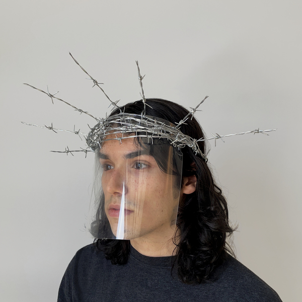 Man wearing artwork made of a clear face shield and barbed-wire crown