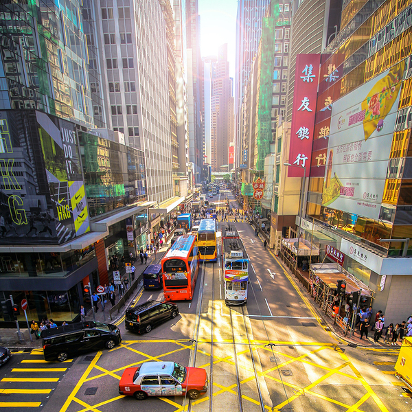 Photo of a busy city intersection, with vehicles backed up trying to make a turn onto a high-traffic street
