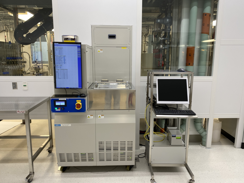 Photo of MIT.nano’s reactive-ion etching system, a large metal box several feet wide and perhaps 5 feet tall, with an attached monitor as well as a separate computer and keyboard on a wheeled tray