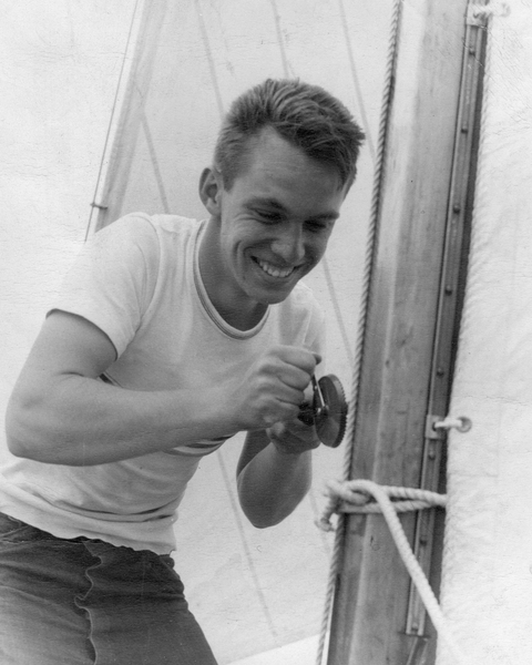 Black and white photo of a young Justin "Jake" Kerwin on a sailboat
