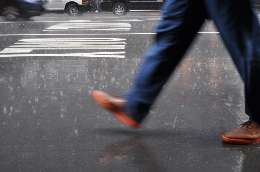 Slightly blurred image of a step being taken on a rainy street.