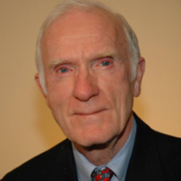 Headshot of an older man who is smiling slightly at the camera