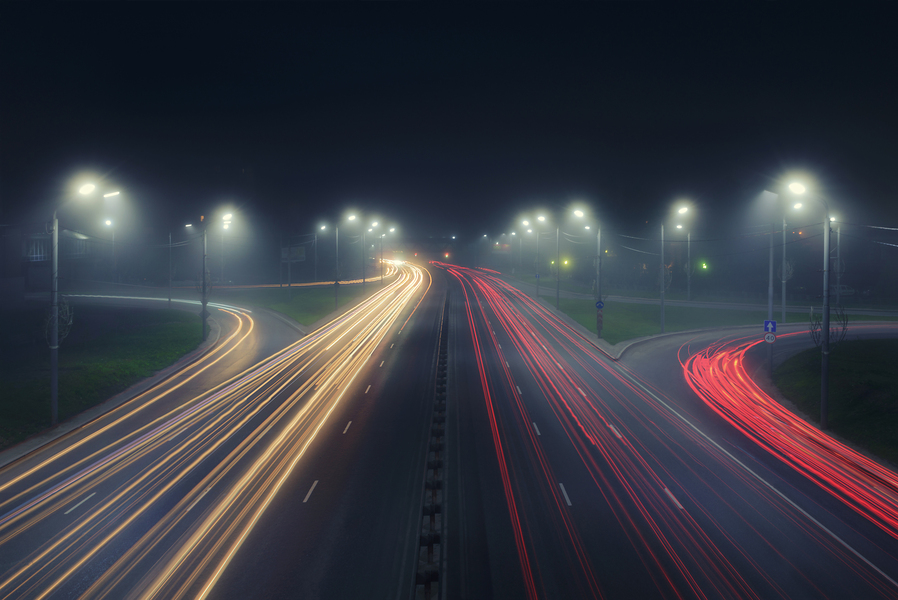 Photo of a highway at night showing vehicle light trails 