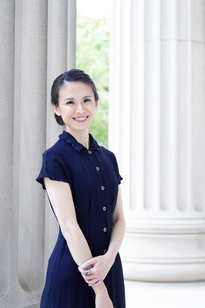 Photo of Meicen Sun standing between two columns of an MIT building