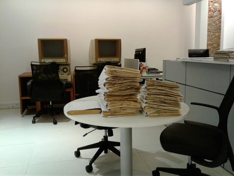 Photo of archive files stacked on table