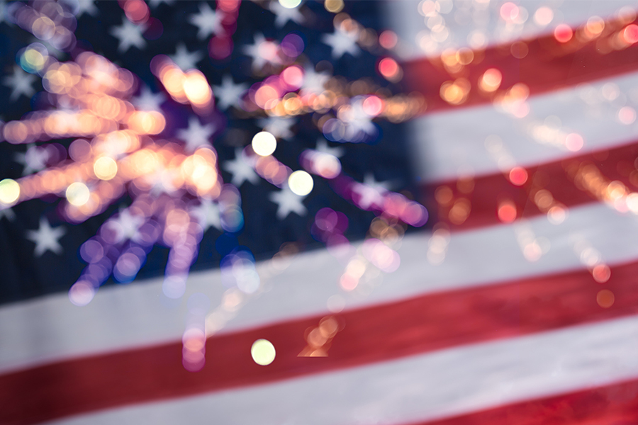Blurry image of a U.S. flag with splashes of colored light