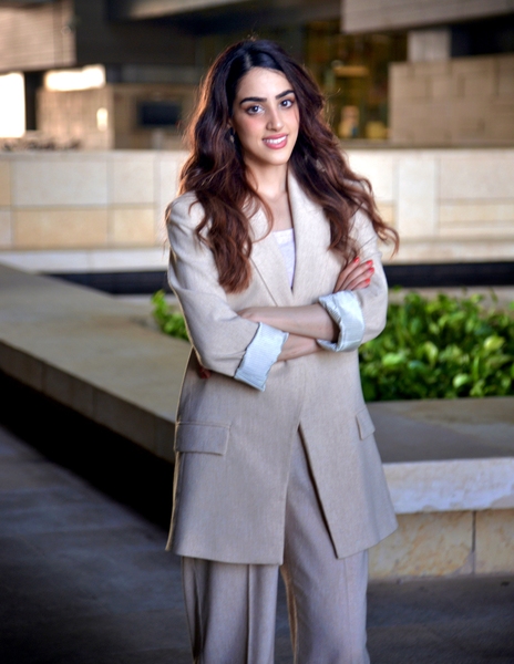 Photo of Dana al Sulaiman standing outdoors in front of a building with her arms crossed