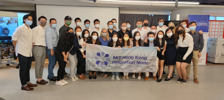 A large group of students, all wearing face masks, pose for a photo with industry partners at the MEFTI Showcase.