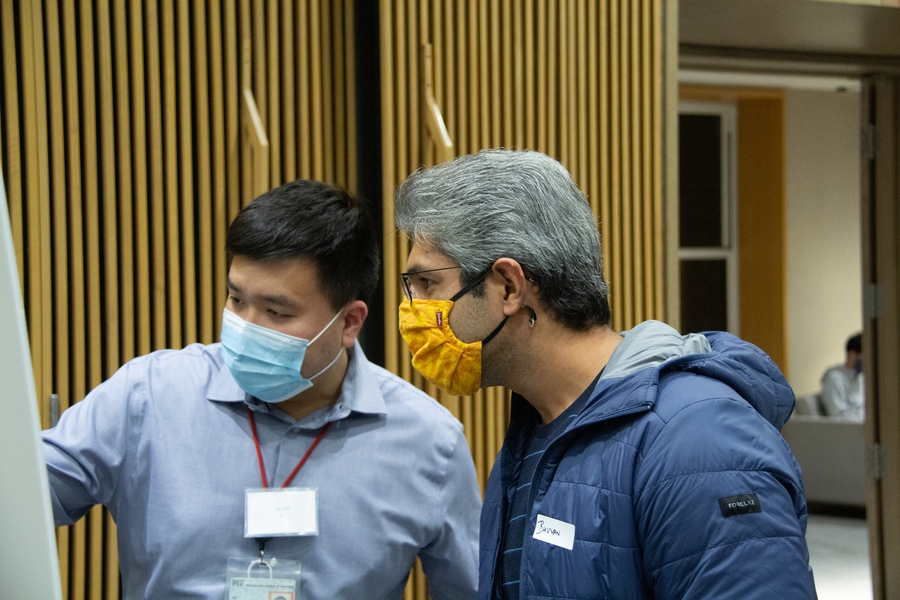 Photo of two men examining a poster
