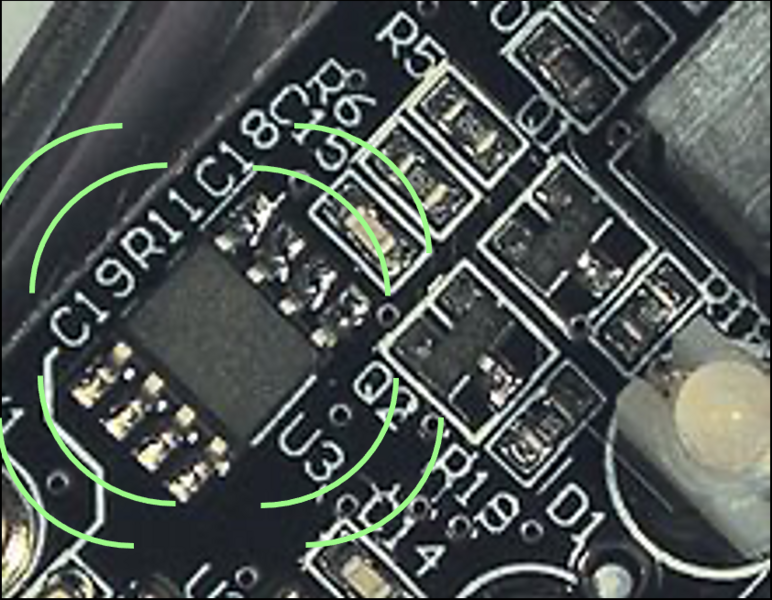 A close up image of a circuit board with 8 green lines emanating from a component on the board.