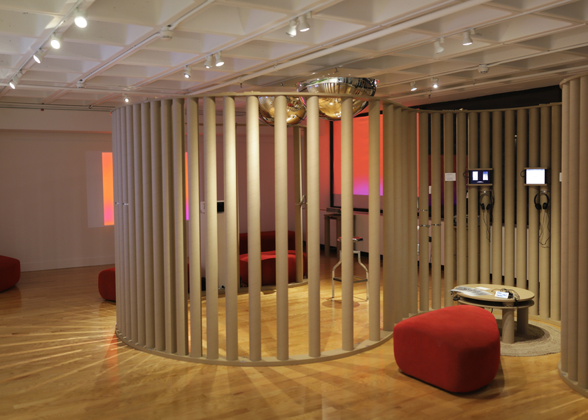 Photo of the virtual storytelling installation gallery with curving brown columns and red bench