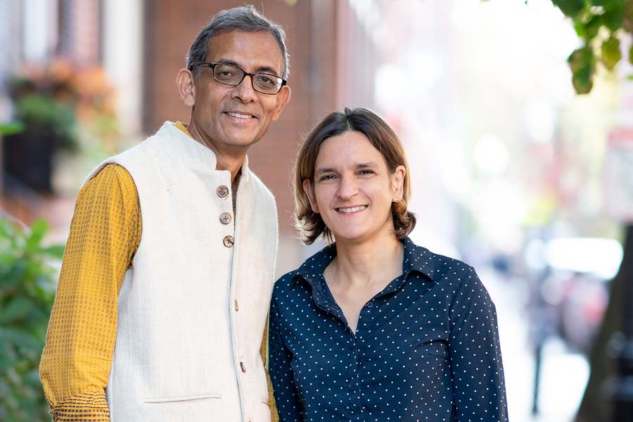 Photo of Abijit Banerjee and Esther Duflo standing side-by-side against a blurred background