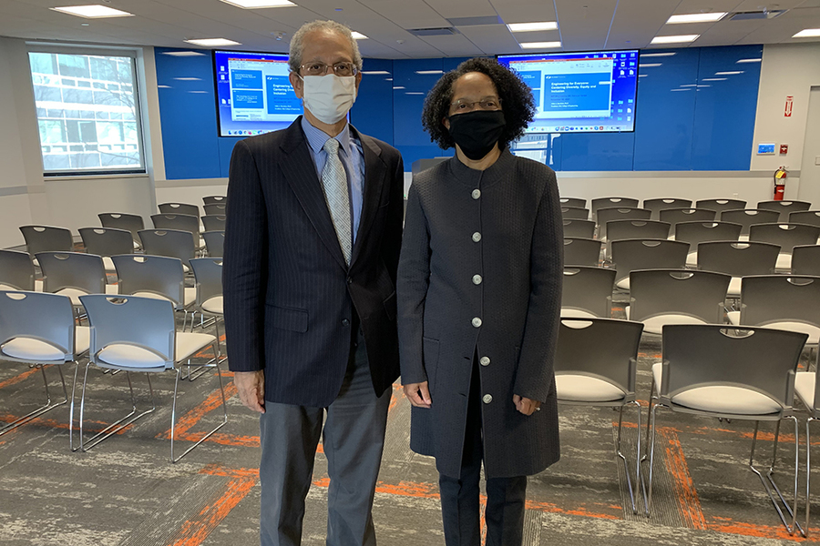Daniel Hastings and Gilda Barabino, both wearing face masks, stand in an empty classroom