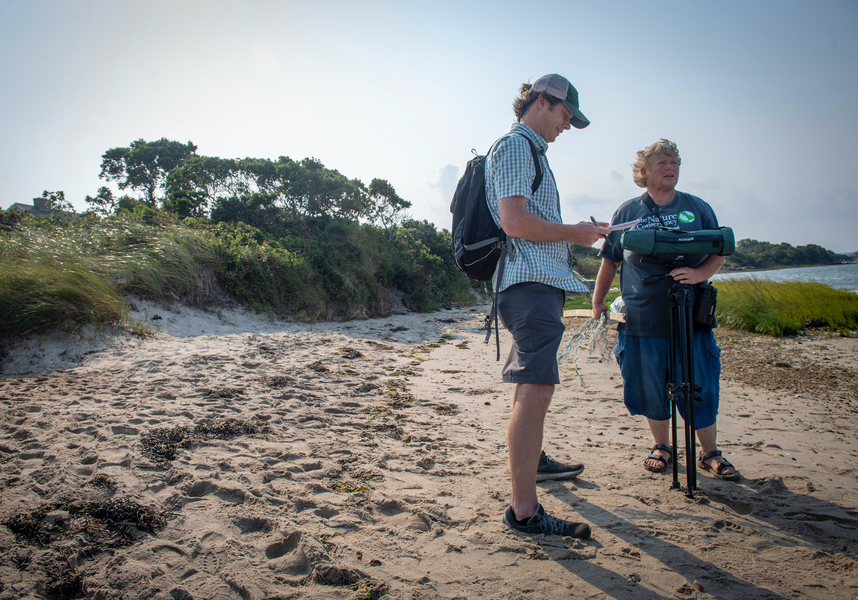 Photo of ESI Journalism Fellow Tristan Baurick standing on a beach with another person