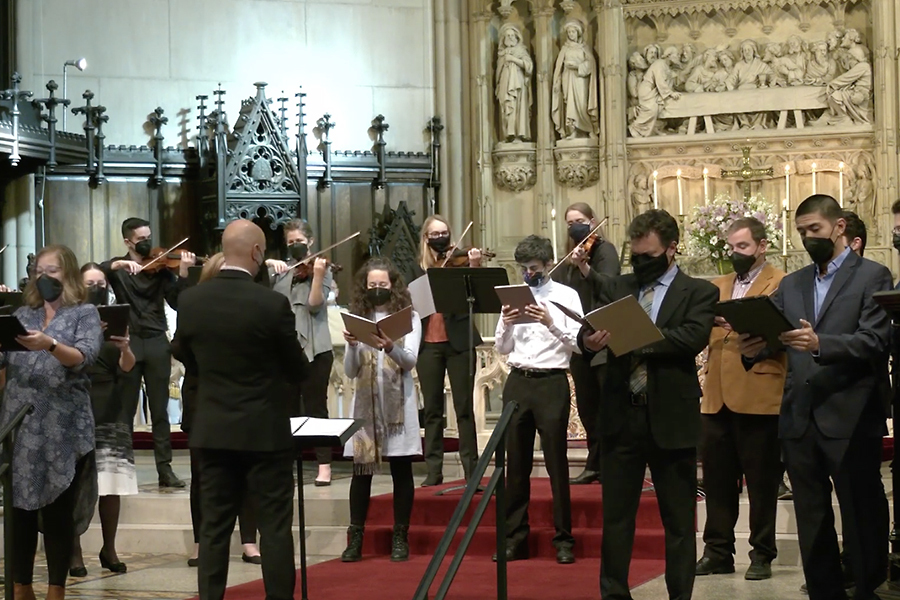 Singers and musicians performing in a chuch, led by a conductor