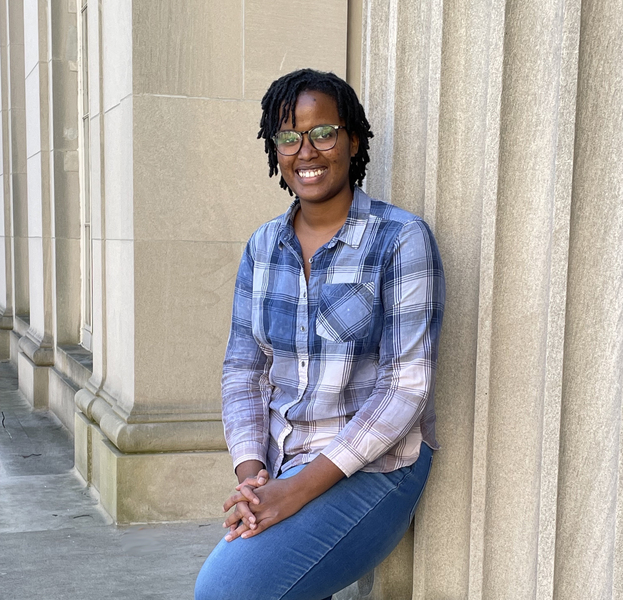 Photo of Carene Umubyeyi standing against building columns