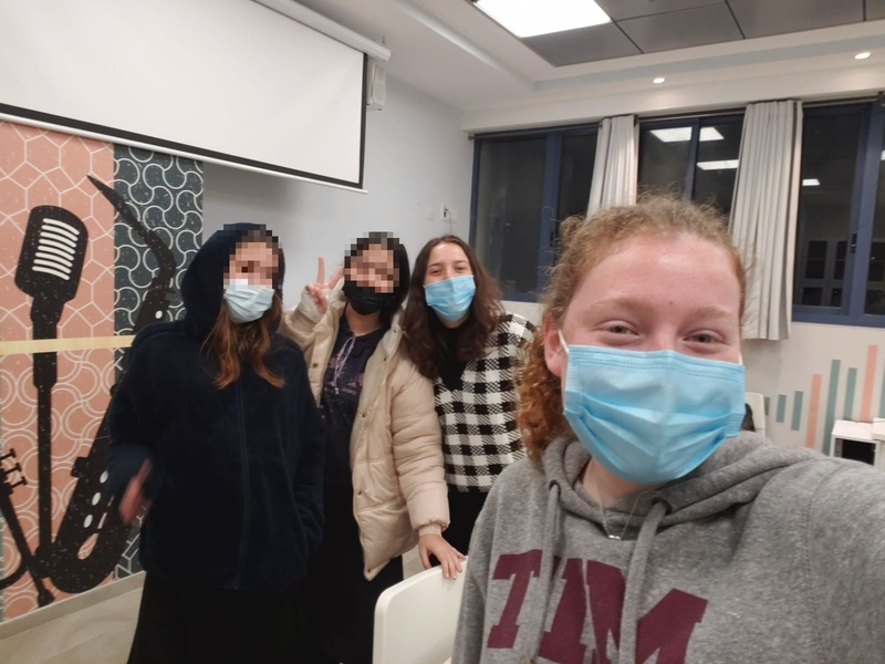 Photo of Marilyn Meyers and three students, two of them blurred, wearing face masks in a classroom