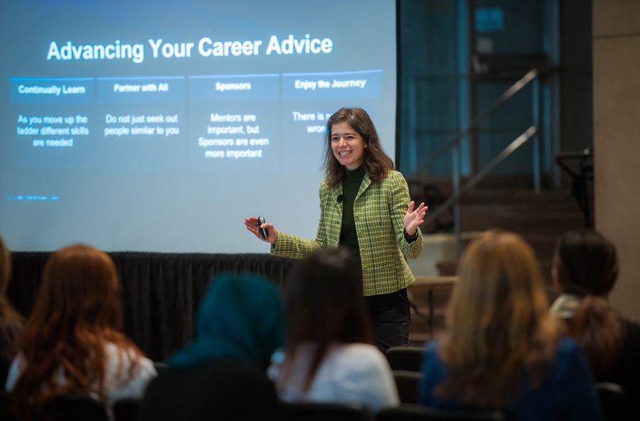 Photo of AMD Corporate Vice President Kim Vo standing before an audience, with a slide projected behind her titled "Advancing Your Career Advice"