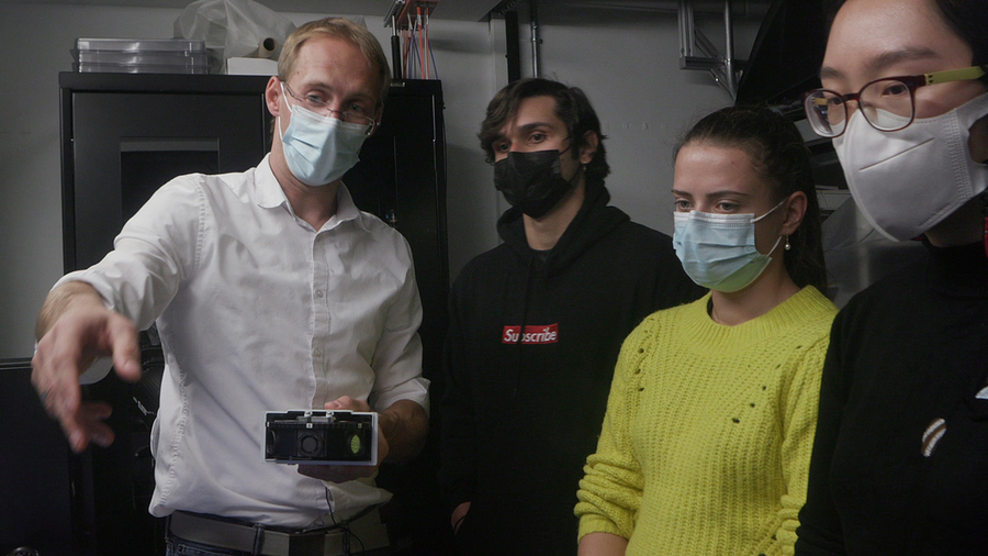 Photo of Mathias Kolle instructing students in the lab