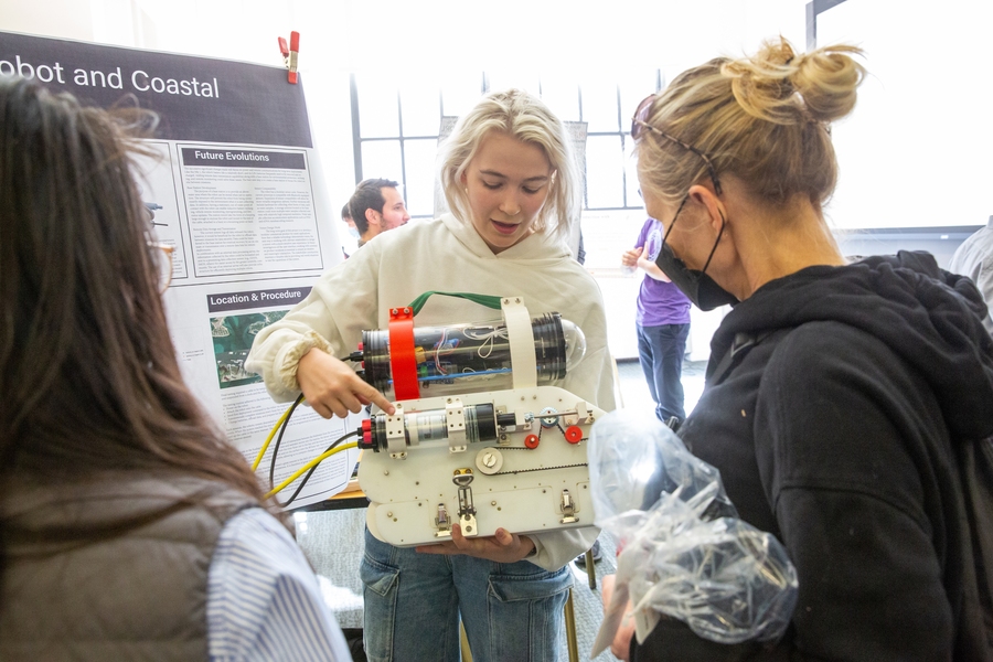 Photo of Arianna Ilvonen holding a marine coastal monitoring robot at the Health of the Planet Showcase