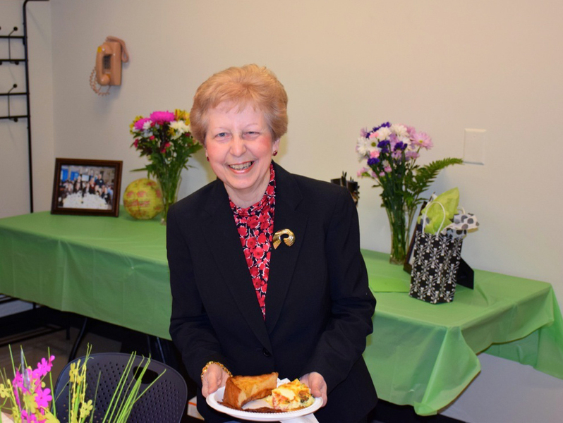 Photo of Maria Bachini, seated with a plate of food on her lap.