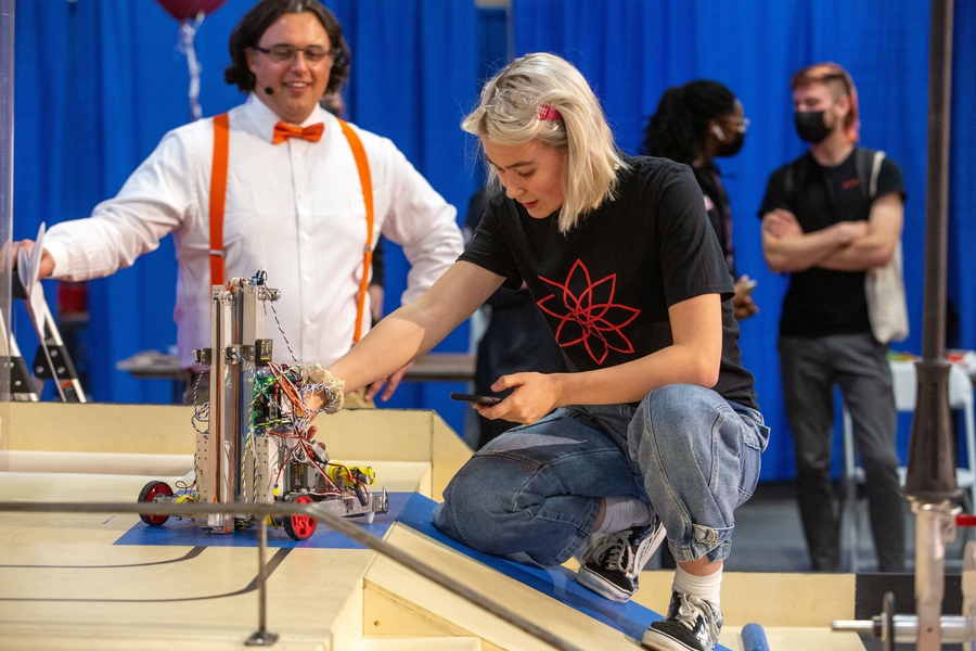 Photo of Arianna Ilvonen examining her robot