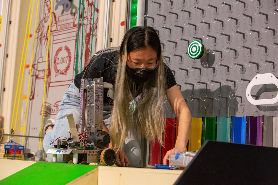 Photo of Erica Chen, kneeling and making adjustments to her robot