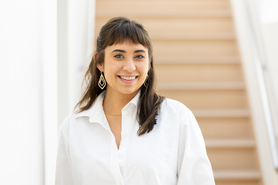 Portrait photo of Jessica Chomik-Morales standing in front of a staircase