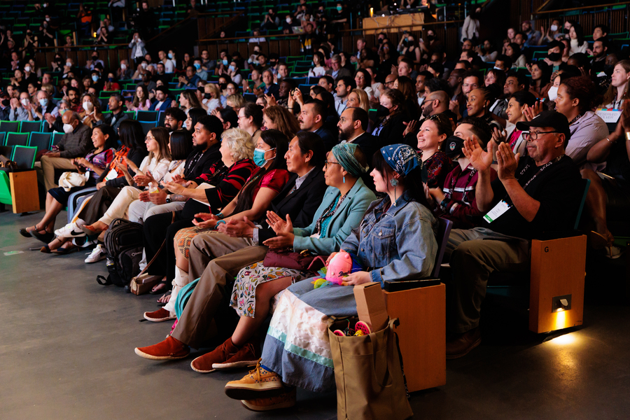 Photo of an audience, mostly unmasked, in a crowded auditorium listening to speakers during Solve at MIT