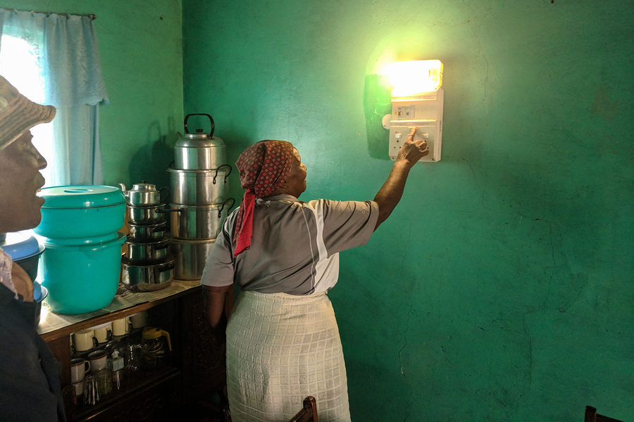 A Lesotho woman turns on a light in her home