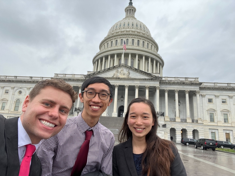 Photo of Dylan Wootton, James Diao, and Emi Lutz taking a selfie in front of the U.S. Capitol