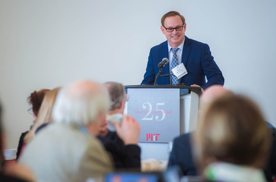 Photo of Norman Magnuson standing at podium, speaking and smiling