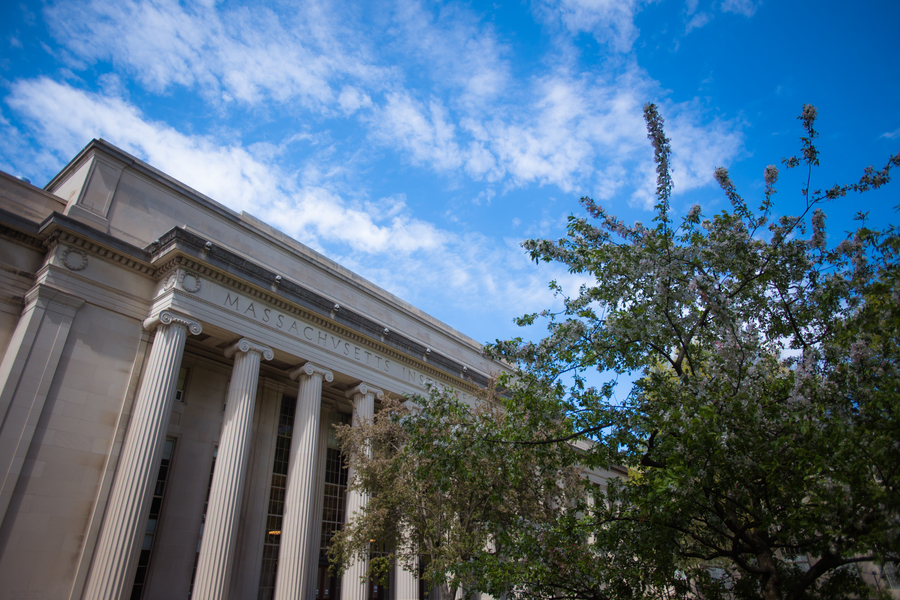 Photo of MIT Building 10, which has columns in front, as well as a tree in bloom