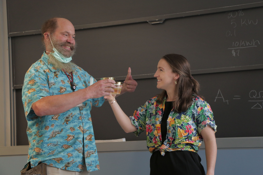 Professor Alexander Slocum and Hilary Johnson toast drinks in a classroom