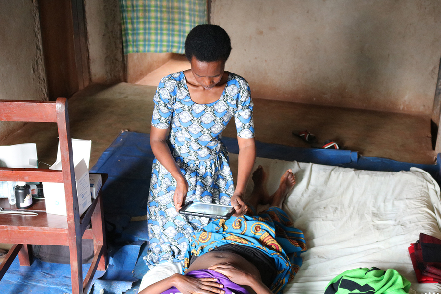 Woman using a tablet computer to take a photograph of a patient's C-section wound