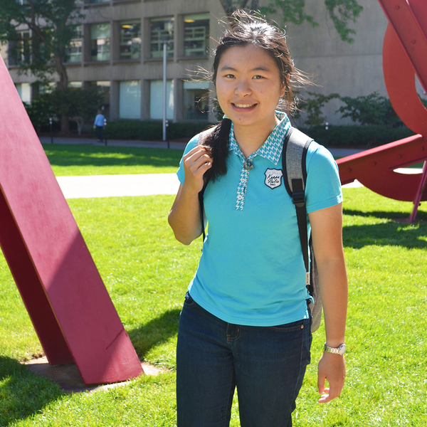 Photo of Sherry Nyeo outdoors on MIT's Hockfield Court, with a red sculpture and an MIT building behind her