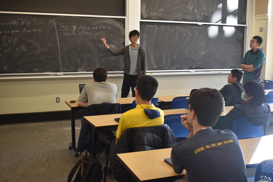 At a blackboard in front of a classroom, Mark Saengrungkongka demonstrates the solution to a math problem.