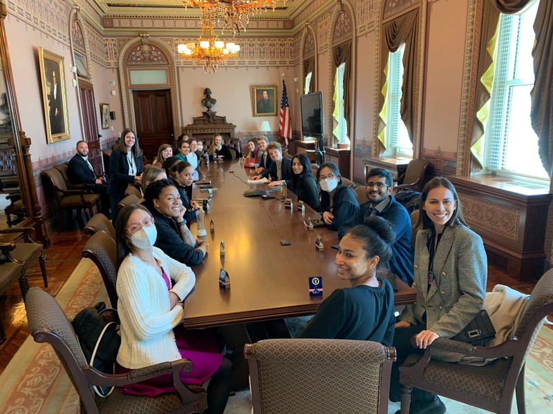 MIT and UDC students and representatives from the US Digital Service sit around a long conference table in a formal room in the Eisenhower Executive Office Building.