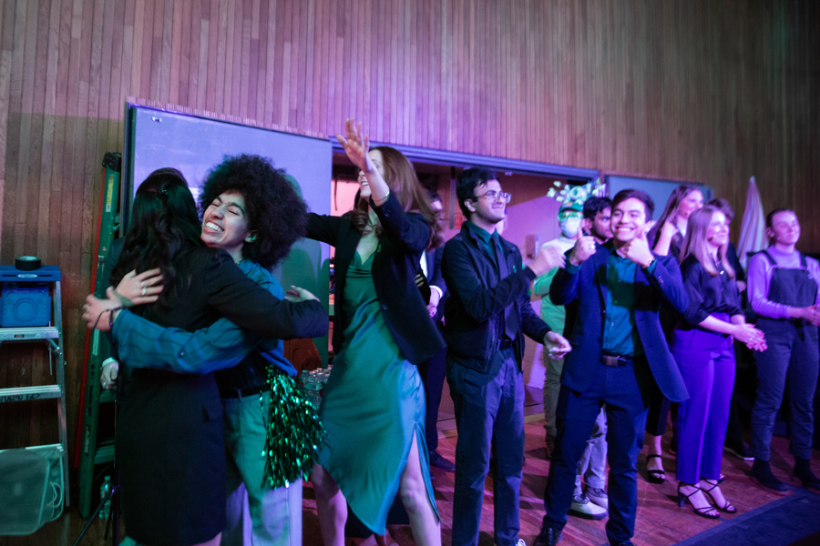 Happy Green Team members give hugs and thumbs up to each other.