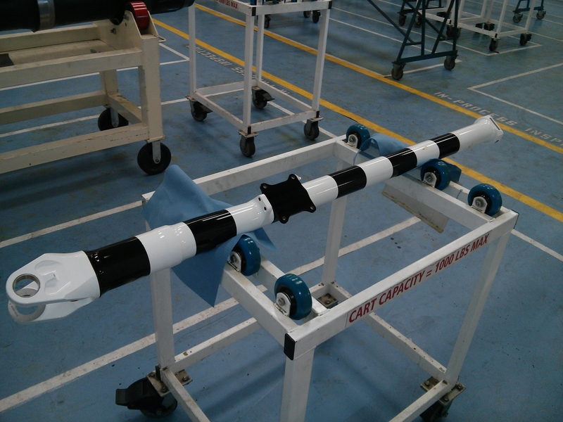 Photo of a steel cylinder painted with black-and-white stripes, sitting on a wheeled cart in a lab