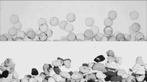 Video of glass spheres (top) and natural river gravel (bottom) undergoing bed load transport in a laboratory flume, slowed down 17x relative to real time.