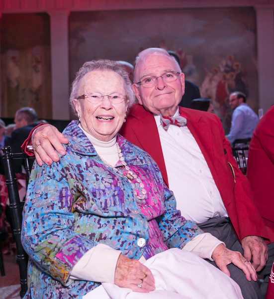 Priscilla and Paul smile for the camera as the sit in the audience. Paul wears a red coat symbolizing he is an MIT alumnus.