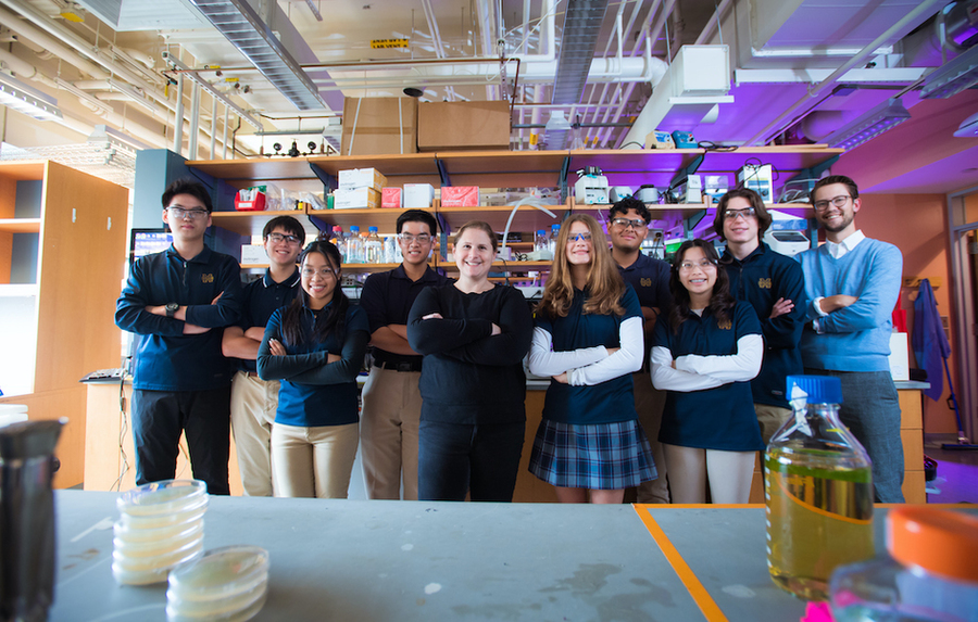 Group portrait of nine high school students and an MIT instructor standing together in lab.